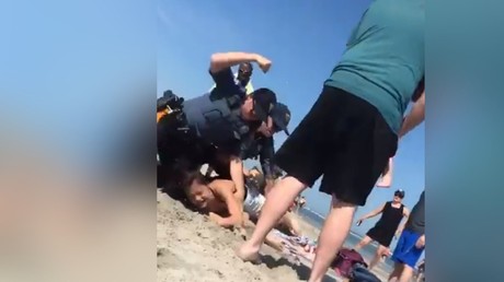 Sur une plage du New Jersey le 26 mai, la jeune Emily Weinman au sol, avant de prendre un coup de poing dans la tempe par un policier qui voulait l’interpeller car elle avait refusé de lui donner son identité.