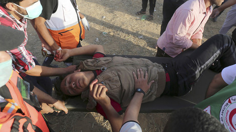 Des Palestiniens portent un blessé à la frontière entre Gaza et Israël, le 22 juin
