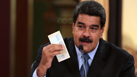 Le président vénézuélien Nicolas Maduro tient dans la main un billet de la nouvelle devise nationale : le bolivar souverain.