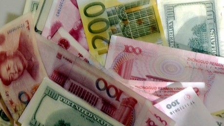 Des billets de dollars, d'euros et de yuans mélangés sur une table (image d'illustration).