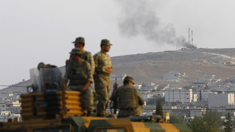 Des soldats turcs à bord d'un véhicule blindé, observant la ville syrienne de Kobané, le 3 octobre 2014.
