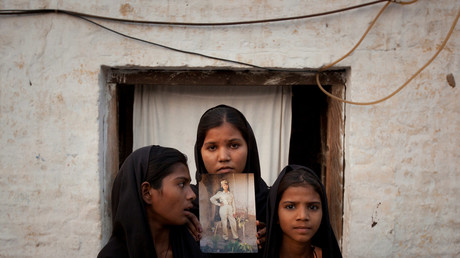 Les filles d'Asia Bibi posant avec une photo de leur mère devant leur maison de Sheikhupura dans la province pakistanaise de Punjab en novembre 2010.