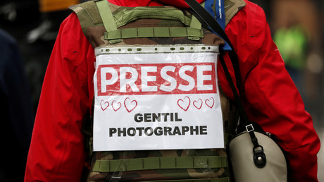 Un journaliste présent lors de la manifestation à Paris arbore un dossard avec des cœurs 
