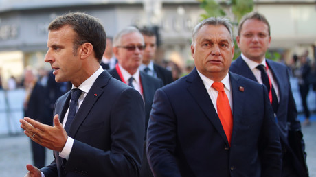  Viktor Orban arrive à  la réunion informelle des dirigeants de l'Union européenne à Salzbourg, en Autriche, alors que le président français Emmanuel Macron s'adresse aux médias, le 20 septembre 2018. 