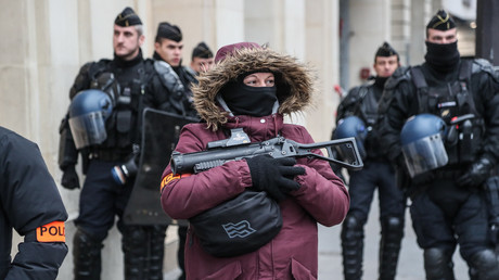 Une policière patrouille dans Paris lors d'une manifestation des Gilets jaunes, le 15 décembre 2018. Dans ses mains, un LBD40.