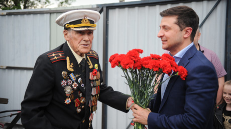 Volodymyr Zelensky offre des fleurs à l'officier de l'armée soviétique Ivan Zaluzhny, lors d'une réunion avec des vétérans de la Seconde Guerre mondiale, le 8 mai 2019. 
