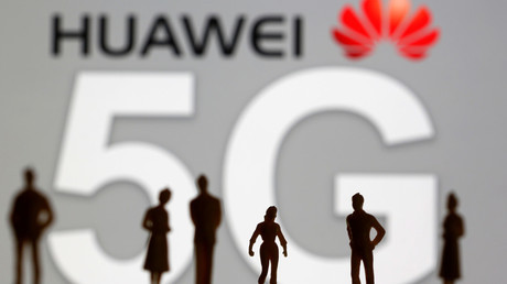 Silhouettes se détachant sur le logo de l'entreprise chinoise Huawei (illustration). 