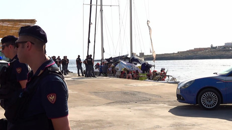 Des policiers italiens se déploient près d'un voilier qui vient d'accoster à Lampedusa  avec 41 migrants à bord, le 6 juillet 2019. 