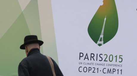 Un passant marche devant des affiches du Sommet mondial sur le climat de la COP 21 à Paris, en 2015.