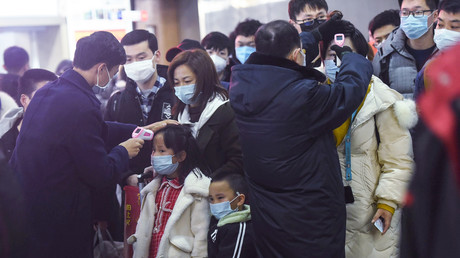 Les membres du personnel vérifient la température corporelle des passagers après l'arrivée d'un train en provenance de Wuhan à la gare de Hangzhou, dans la province orientale du Zhejiang en Chine, le 23 janvier.