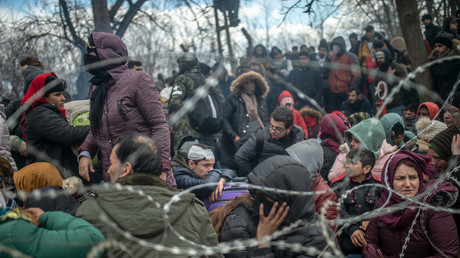 Des migrants sont assis derrière une clôture en fil de fer barbelé dans la zone tampon à la frontière turco-grecque à Pazarkule, dans le district d'Edirne, le 29 février 2020 (image d'illustration).