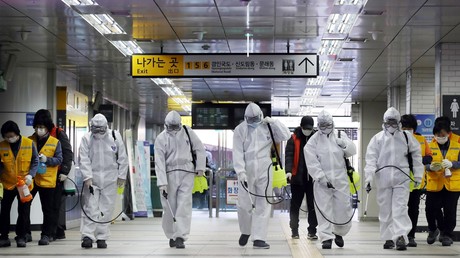 Des travailleurs portant un équipement de protection désinfectent une station de métro à Séoul, le 11 mars 2020 (image d'illustration).