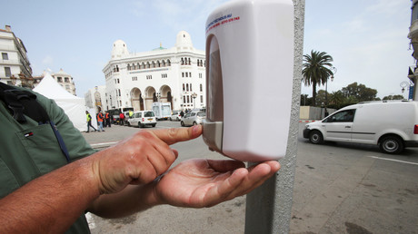 Un homme utilise un distributeur de désinfectant pour les mains dans la rue après la propagation de la maladie à coronavirus (COVID-19), à Alger (Algérie), le 21 mars 2020.