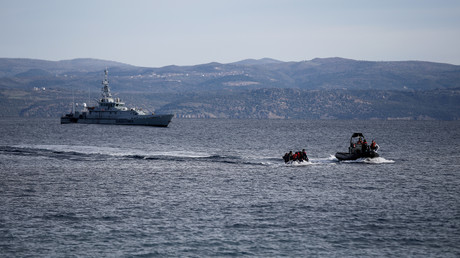 Un bateau de sauvetage escorte un canot avec des migrants en provenance d'Afghanistan alors qu'un navire Frontex patrouille en arrière-plan, sur l'île de Lesbos (Grèce) (image d'illustration).