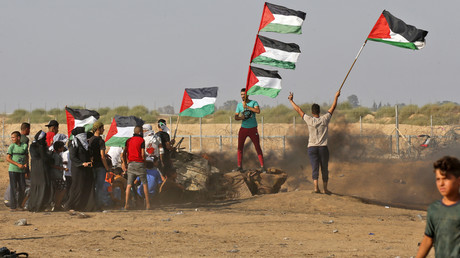 Des manifestants palestiniens brandissent le drapeau national à la suite d'une manifestation frontalière à l'est de Khan Yunis dans le sud de la bande de Gaza le 23 août 2019. (Image d'illustration)