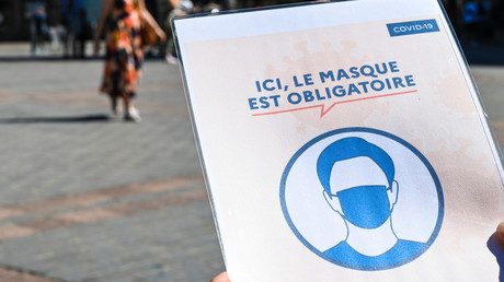 Des personnes portant des masques de protection passent devant un panneau indiquant «Ici, le masque de protection est obligatoire» dans une rue de Lille, le 30 juillet 2020 (image d'illustration).