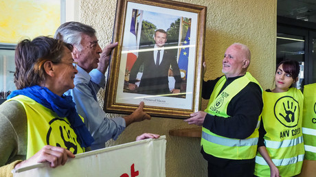 Des militants d'ANV COP21 en train de décrocher un portrait d'Emmanuel Macron à la mairie de Cabestany le 27 février 2019. (Image d'illustration)