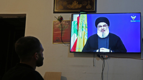 Homme regardant le discours du chef chiite Hassan Nasrallah à la télévision dans une boutique le 29 septembre à Houla au Liban (image d'illustration).