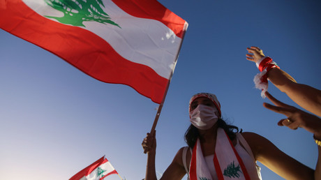 Une manifestante libanaise lève un drapeau national lors d'une manifestation marquant le premier anniversaire du début d'un mouvement de protestation antigouvernementale à l'échelle nationale, dans la capitale Beyrouth le 17 octobre 2020 (image d'illustration).