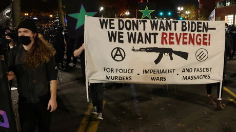 Des manifestants munis d'une banderole portant le slogan  «On ne veut pas de Biden, on veut la vengeance  -  Pour les meurtres commis par la police, les guerres impérialistes, et les massacres fascistes», à Portland, dans l'Oregon, le 4 novembre 2020.