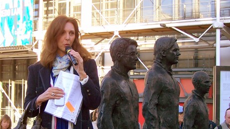 La lanceuse d'alerte Stéphanie Gibaud devant les statues d'Edward Snowden, Julian Assange et Chelsea Manning, près du centre Pompidou à Paris, en septembre 2015.