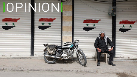 Un homme assis devant un magasin fermé, affichant le drapeau syrien, le 10 mars 2021 à Douma (illustration).