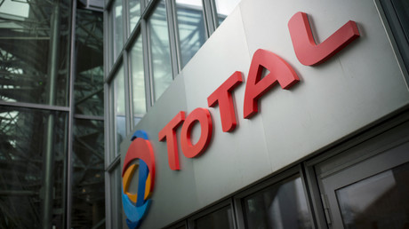 Le logo de Total affiché au dessus de l'entrée de son siège social situé dans le quartier de la Défense proche de Paris le 21 octobre 2014.