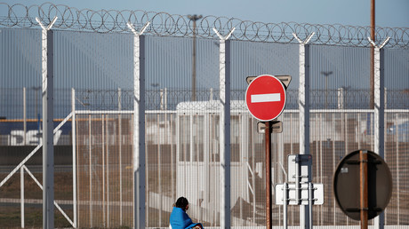 Un migrant assis devant la clôture entourant le port de Calais, le 21 février 2019 (image d'illustration)