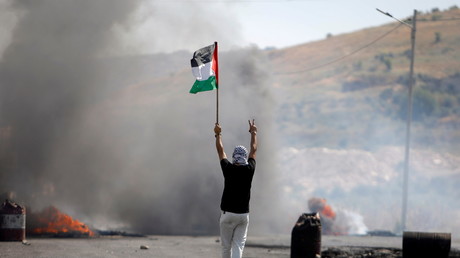 Un manifestant tenant un drapeau palestinien à Naplouse, en Cisjordanie, le 14 mai 2021.