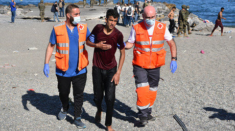 Des membres de la Croix rouge espagnole aident un migrant qui vient tout juste d'arriver à Ceuta après une traversée à la nage le 18 mai 2021 (image d'illustration).