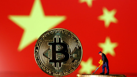 Saynète réalisée avec une figurine de «mineur» sur fond de bitcoins et de drapeau chinois le  9 avril 2019 (illustration).