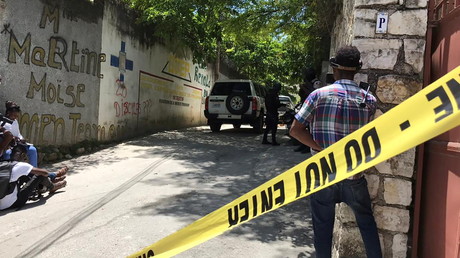 Des journalistes se tiennent à côté d'un cordon de police près de la résidence du président haïtien Jovenel Moise après qu'il a été abattu par des assaillants non identifiés, à Port-au-Prince.