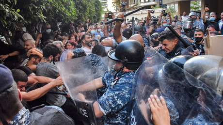 Des manifestants face aux forces de sécurité alors qu'ils tentent de pénétrer dans la résidence du ministre libanais de l'Intérieur, dans l'ouest de Beyrouth, le 13 juillet 2021.