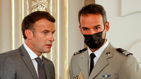 Le président français Emmanuel Macron échange avec son aide de camp lors d'une cérémonie au Palais de l'Elysée le 19 juillet 2021 (image d'illustration).