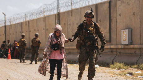 Un Marine américain  assiste une femme lors d'une évacuation à l'aéroport de Kaboul, en Afghanistan, le 22 août 2021.