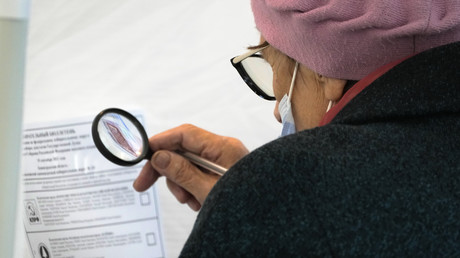 Une électrice russe étudie son bulletin de vote à la loupe (illustration).