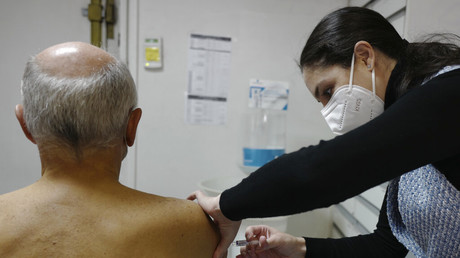 Un homme âgé se fait administrer une dose de rappel dans une pharmacie à Paris le 25 octobre 2021