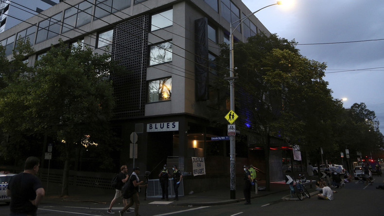 Des personnes se tiennent devant un centre de quarantaine où le champion de tennis Novak Djokovic est détenu à Melbourne, en Australie, du fait de son statut de non-vacciné contre le Covid-19.