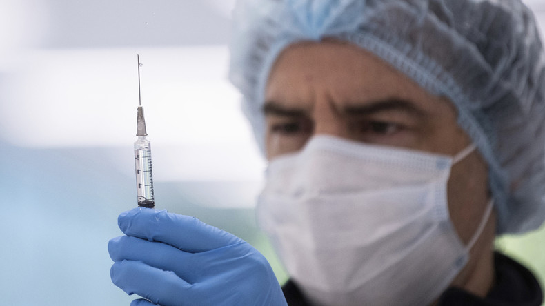 Un homme tenant une seringue de vaccin contre le Covid-19 en Australie