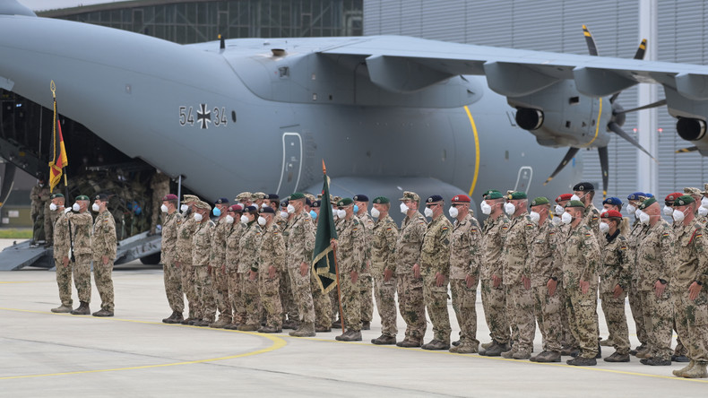 Des soldats des forces armées allemandes de la Bundeswehr s'alignent avec les drapeaux des troupes devant un Airbus A400M cargo à la base aérienne militaire de Wunstorf, dans le nord de l'Allemagne, le 30 juin 2021.