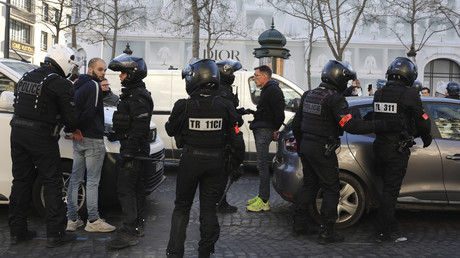 Des policiers interpellent des manifestants lors d'une manifestation sur l'avenue des Champs-Elysées, le 12 février 2022 à Paris.