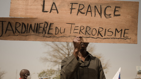 Un manifestant tient une pancarte lors d'une manifestation pour célébrer l'annonce du retrait des troupes françaises du Mali, à Bamako, le 19 février 2022.