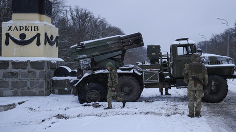 Soldats ukrainiens à côté d'un véhicule russe abandonné dans la région de Kharkov le 25 février 2022