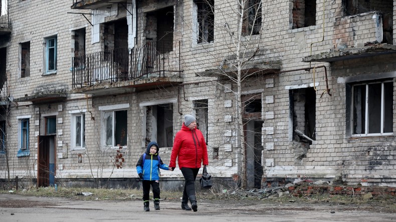 Des civils devant un immeuble détruit à Krasnogorivka, dans la région de Donetsk