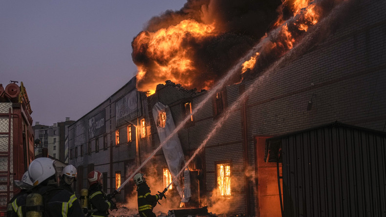 Les pompiers ukrainiens éteignent un incendie dans un entrepôt à Kiev, en Ukraine, le jeudi 17 mars 2022