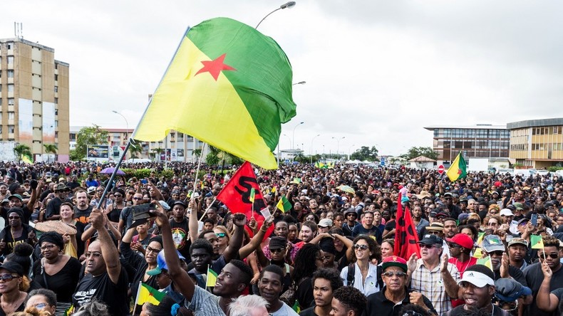 Des manifestants brandissent le drapeau non-officiel de la Guyane lors d'une marche de soutien à la grève générale à Cayenne, le 28 mars 2017