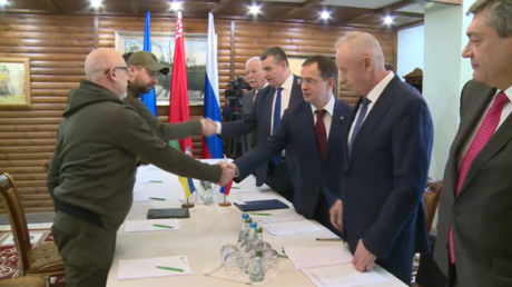 Les délégations ukrainienne et russe se saluent lors des pourparlers entre la Russie et l'Ukraine à la frontière entre la Biélorussie et la Pologne, le 3 mars.