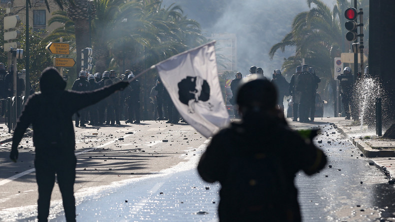 Des manifestants brandissent des drapeaux de la Corse alors qu'ils affrontent la police anti-émeute CRS à Ajaccio le 3 avril 2022,