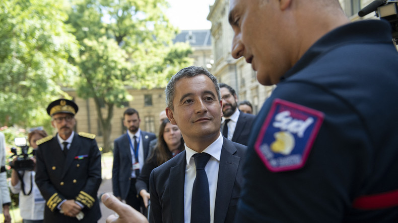 Le ministre français de l'Intérieur Gérald Darmanin avec un pompier lors d'une visite à la préfecture du Rhône, à Lyon, le 30 juillet 2022.