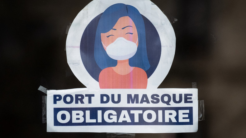 un autocollant indiquant "Le port du masque est obligatoire" sur la porte d'un magasin à Paris., le 13 mars 2022